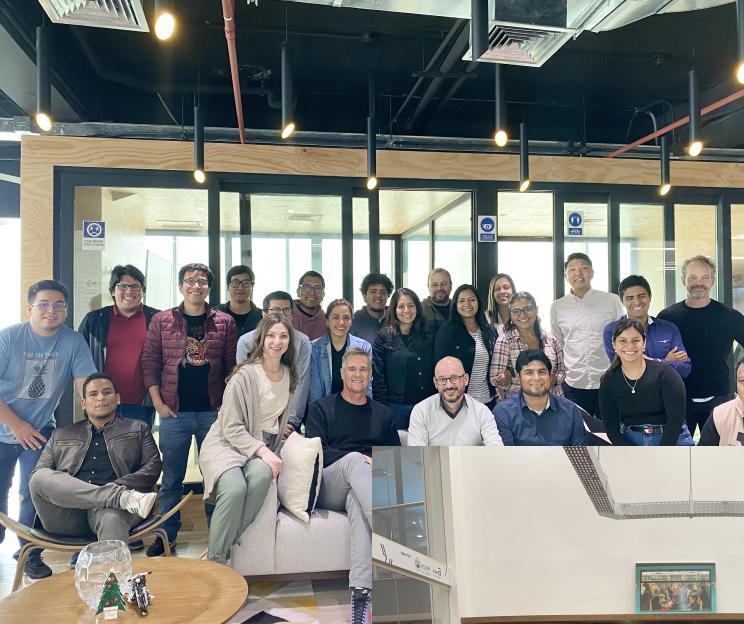 Indoor team photo of 11 members of the Able team in matching black Able company tshirts