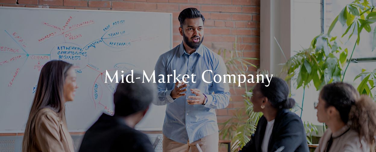 A young professional man leads a small business meeting in modern office conference room space.