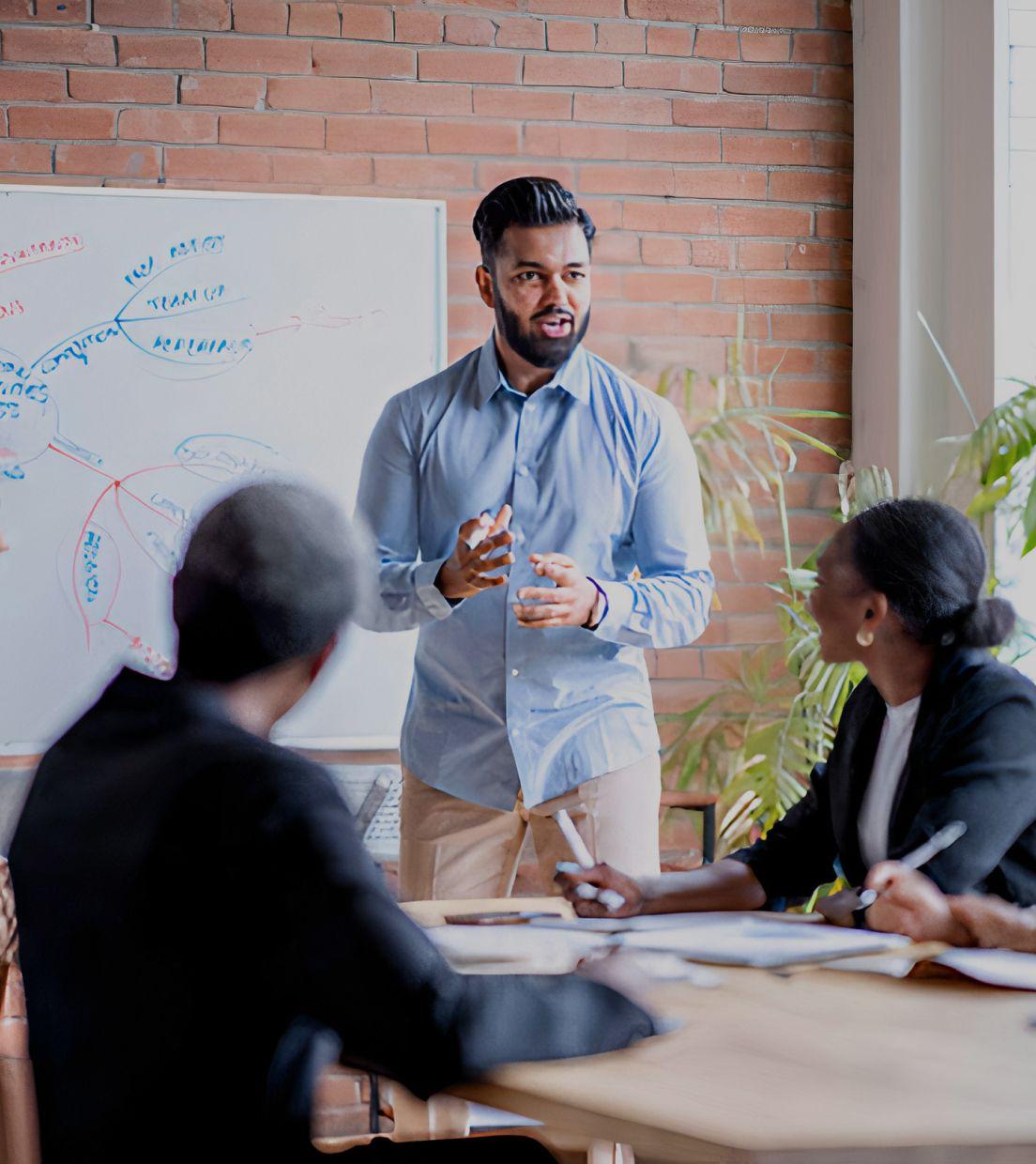 A young professional man leads a small business meeting in modern office conference room space